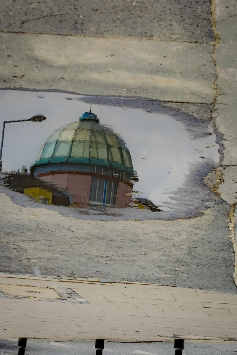 Domed roof reflected in a narrow puddle